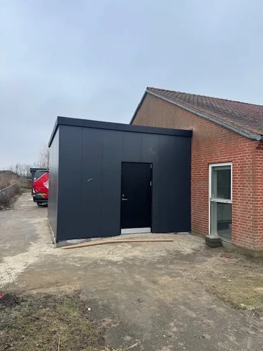 Almindeligt murstenshus med ny tilbygning